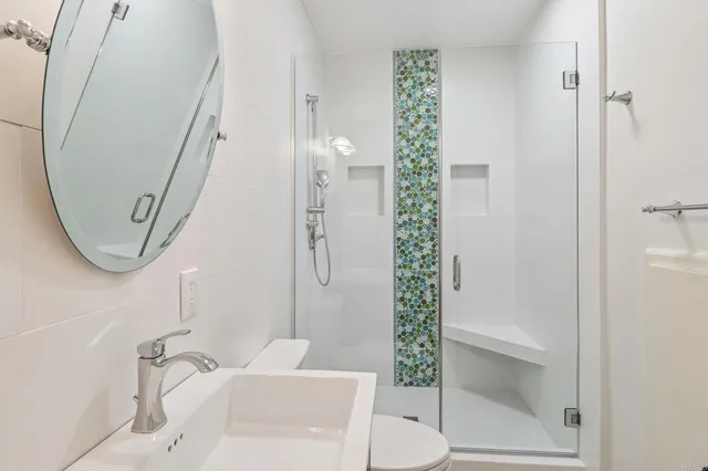 a bathroom with a sink a toilet and shower