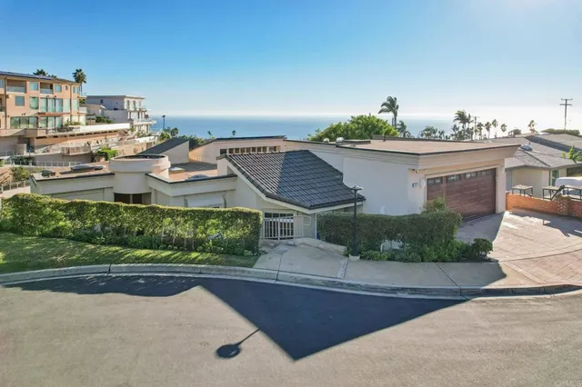 a view of a house with a yard and potted plants