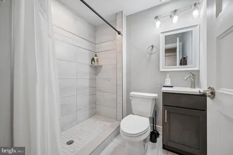 a bathroom with a shower a toilet and sink