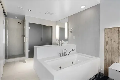 a bathroom with a white bath tub sitting next to a white sink