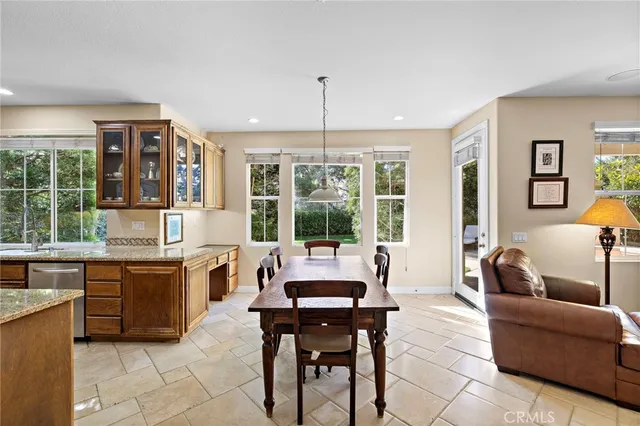 a kitchen with stainless steel appliances granite countertop sink refrigerator and chairs