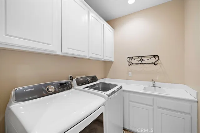 a view of a patio with couches table and chairs and potted plants and big trees