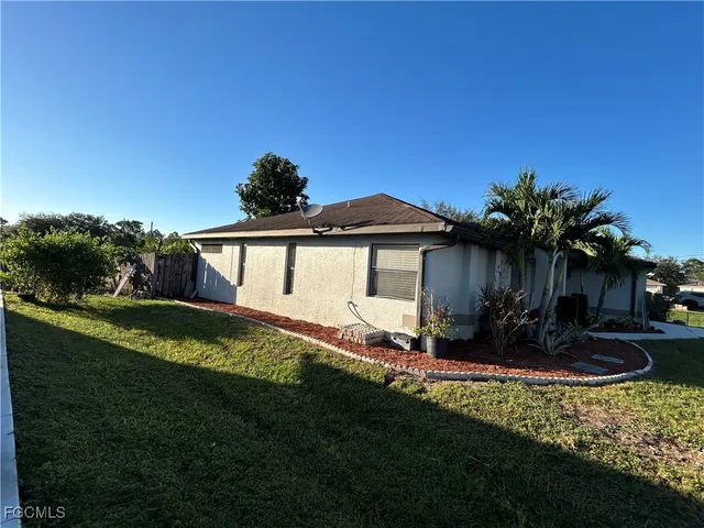 a view of a house with a yard and sitting area