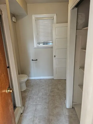 a bathroom with a granite countertop sink and a toilet