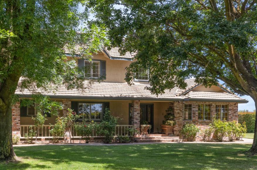 7583 East Realty Road Lodi, CA 95240 - Photo 3 of 41 The covered porch and the mature trees offer cooling shade to this country home.