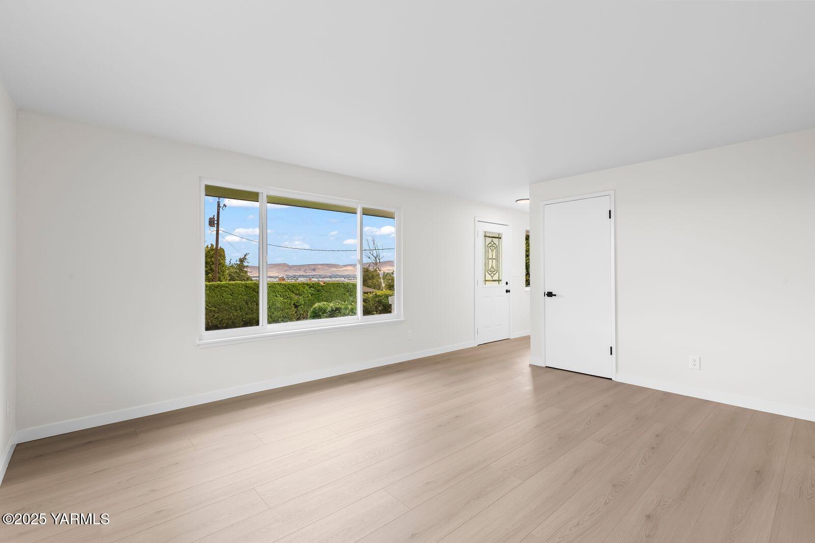 602 Meadowbrook Road Yakima, WA 98903 - Photo 21 of 42 an empty room with wooden floor and windows