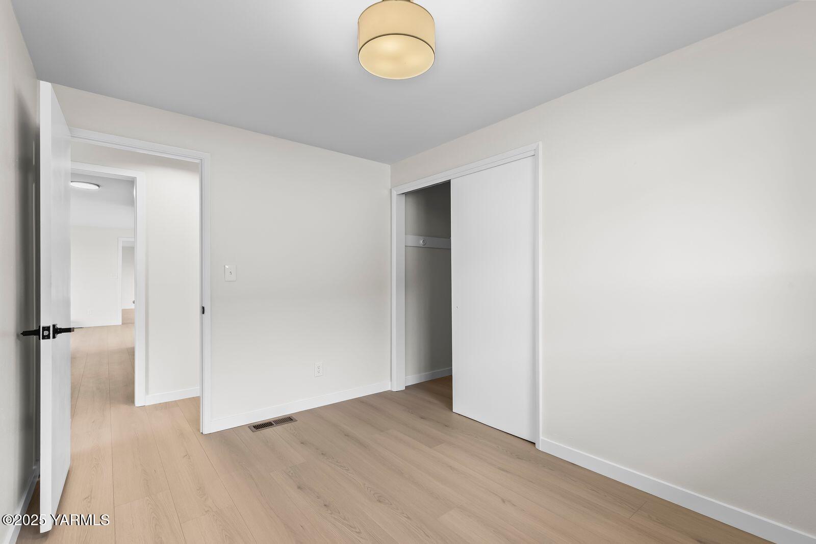 602 Meadowbrook Road Yakima, WA 98903 - Photo 23 of 42 an empty room with wooden floor and windows