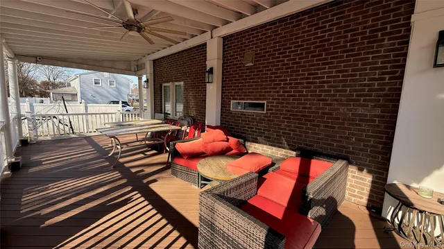 a view of a patio with table and chairs with wooden floor and fence