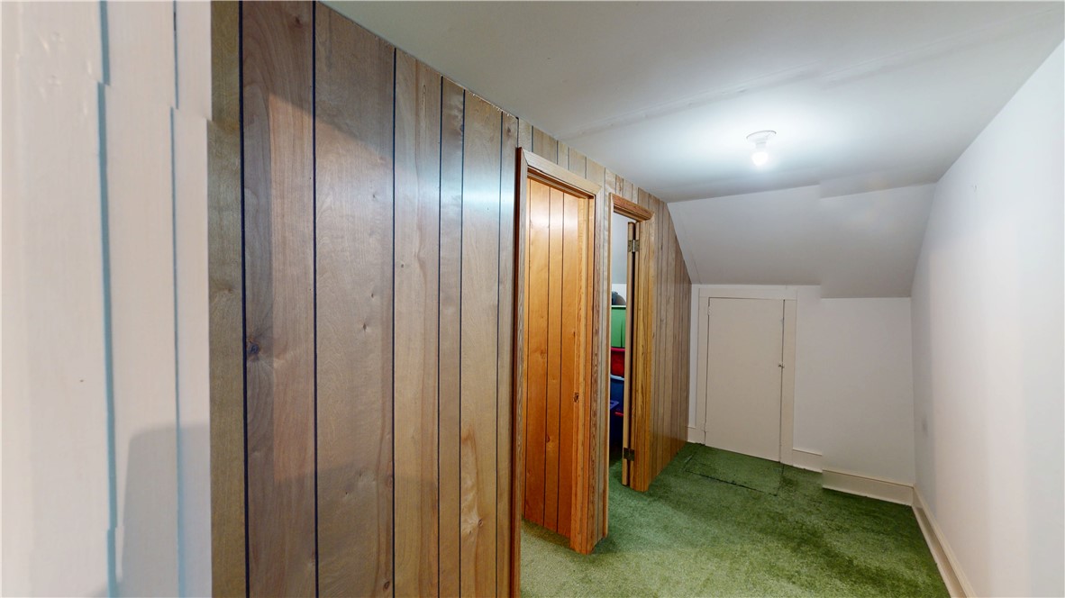 415 Church Street Pendleton, SC 29670 - Photo 28 of 35 A versatile attic space, ideal for storage or potential conversion, features paneled walls and soft green carpeting.