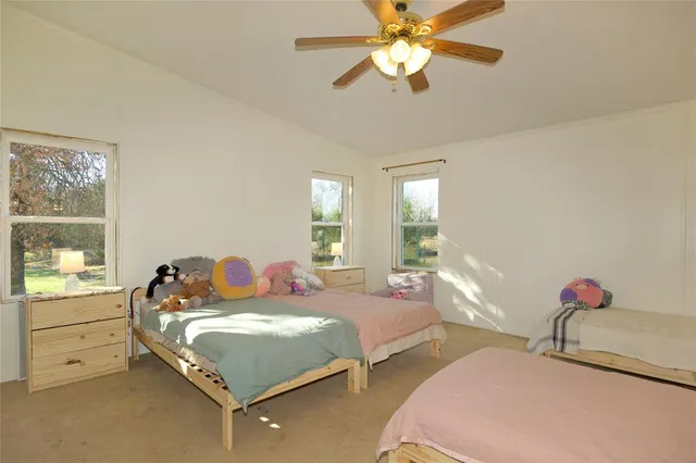 a bedroom with two beds and windows