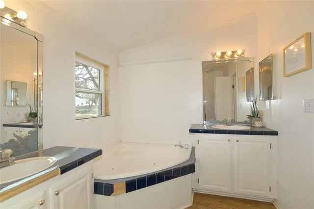 a bathroom with a tub sink and mirror