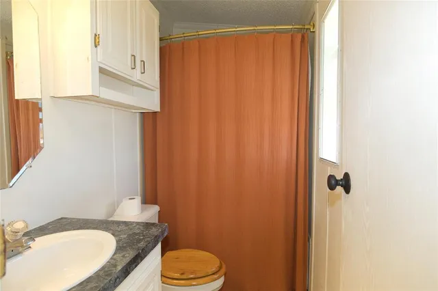 a bathroom with a granite countertop sink toilet and shower