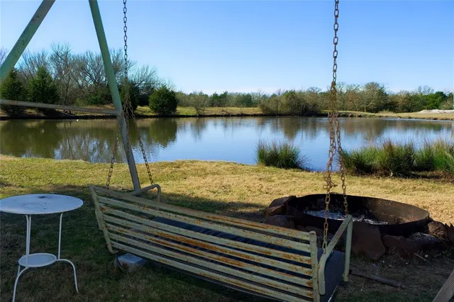 a view of a lake with couches and wooden fence