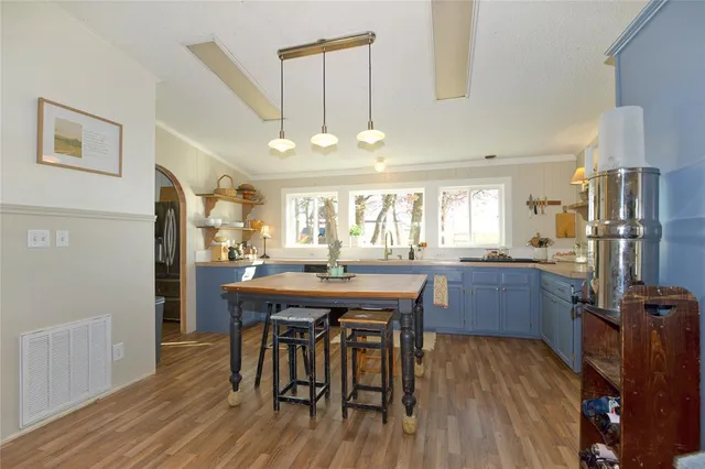 a kitchen with stainless steel appliances wooden floor dining table and chairs