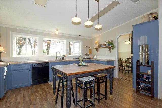a kitchen with stainless steel appliances granite countertop table chairs stove and cabinets