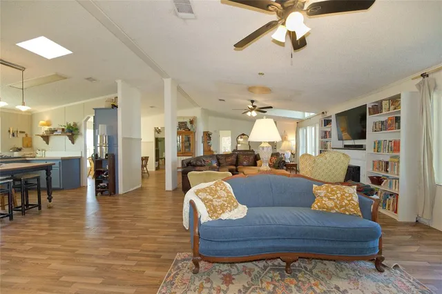 a living room with furniture and a view of kitchen