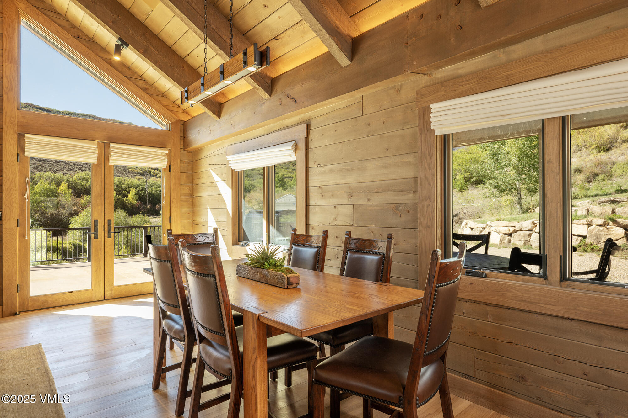 1500 West Sheep Creek Road Gypsum, CO 81637 - Photo 21 of 48 a view of a dining room with furniture large windows and wooden floor