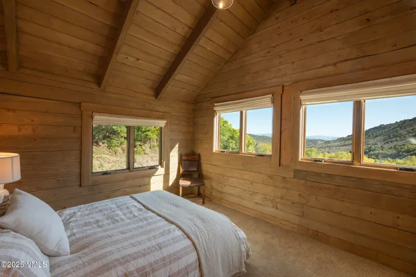 a bedroom with a bed and large glass window