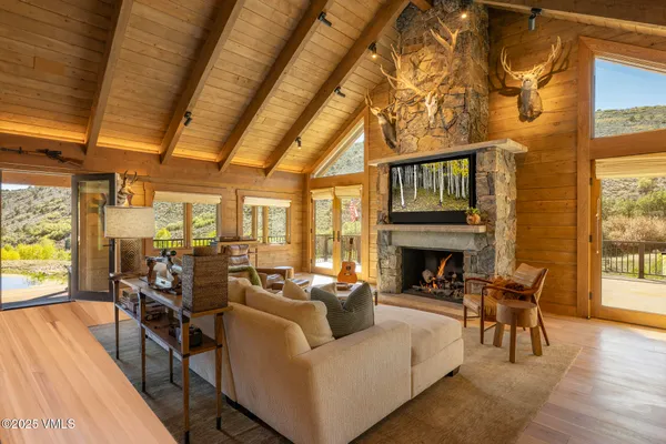 a living room with fireplace furniture and a floor to ceiling window next to a large window