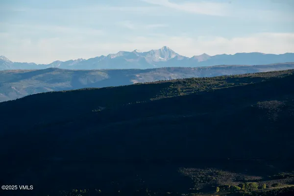 a view of a field with mountains in the background
