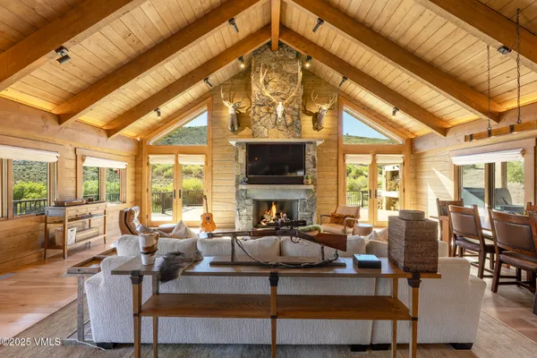 a living room with fireplace furniture and a large window
