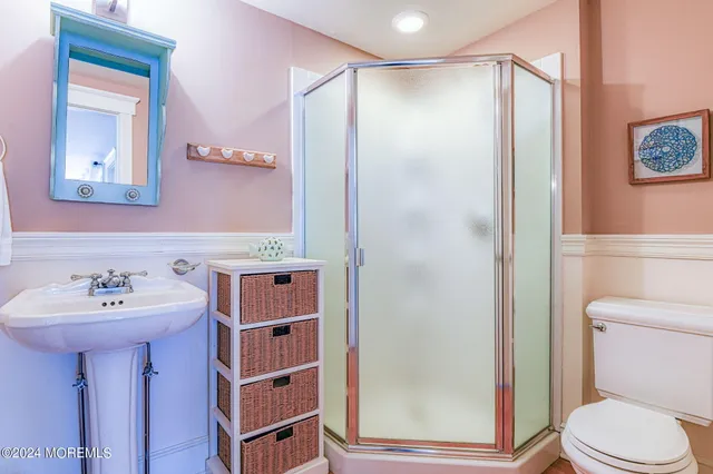 a bathroom with a sink a toilet and shower