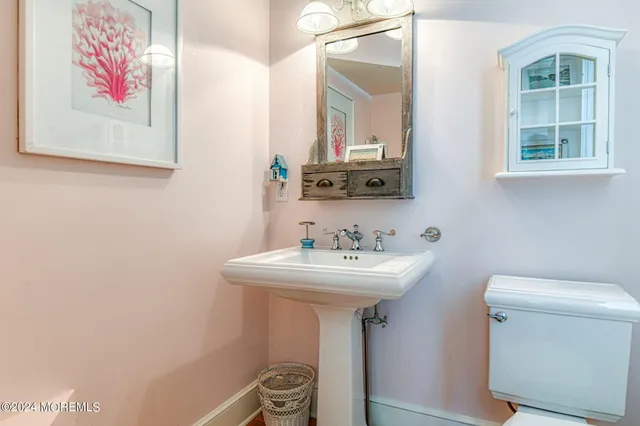 a bathroom with a sink mirror and toilet