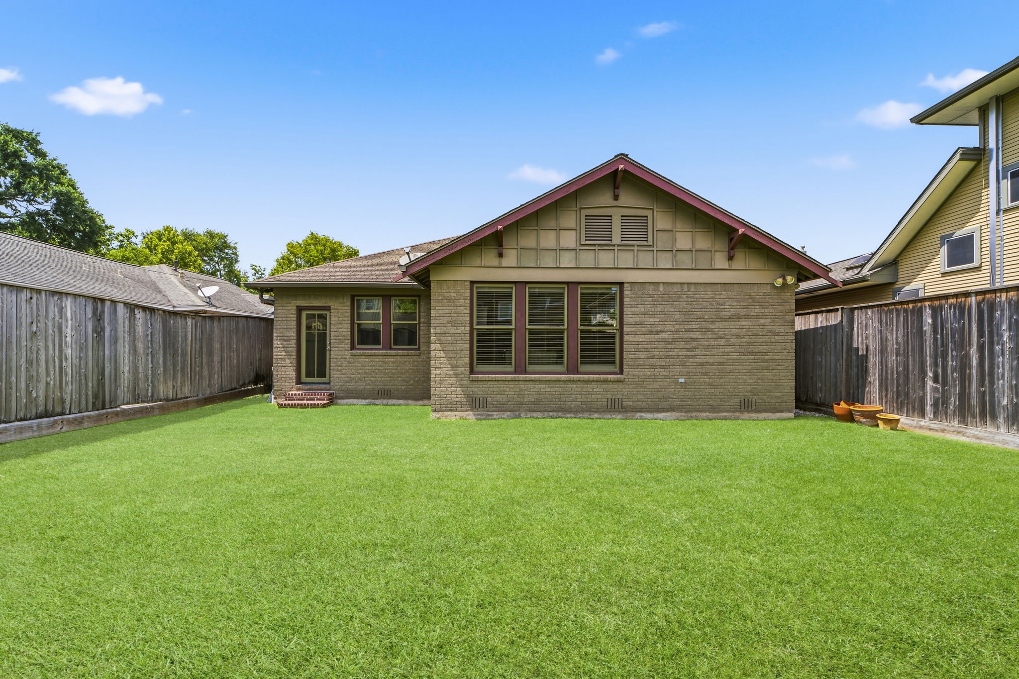 1521 Kipling Street Houston, TX 77006 - Photo 33 of 35 Charming brick home with a spacious, well-maintained backyard, perfect for outdoor activities. The property features a wooden fence for added privacy.