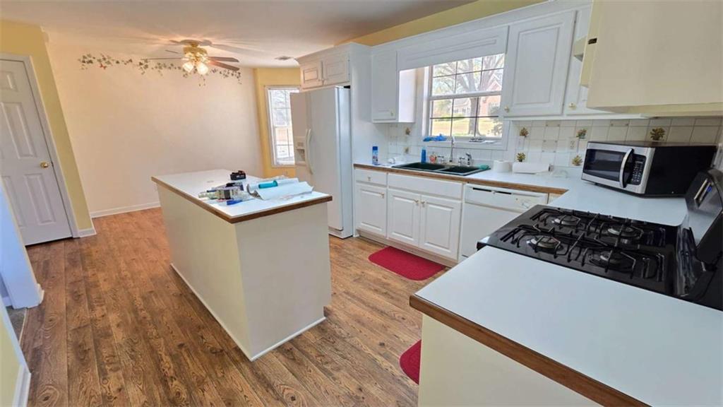 352 Olde Wick Trail Hoschton, GA 30548 - Photo 10 of 34 a kitchen with granite countertop a sink a stove and refrigerator