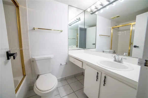 a bathroom with a toilet sink vanity and mirror