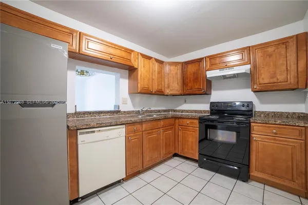 a kitchen with granite countertop cabinets stainless steel appliances and a sink