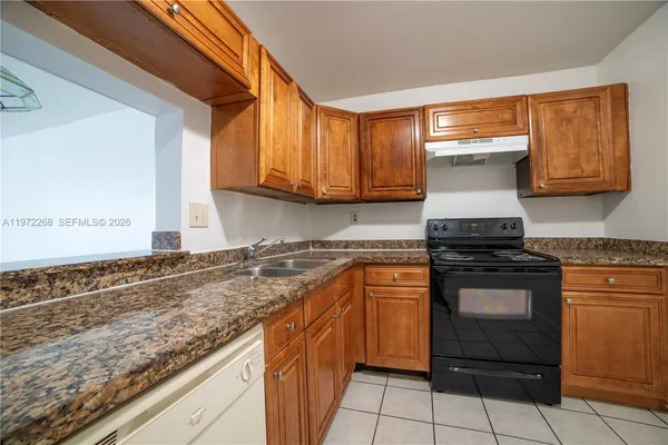 a kitchen with granite countertop cabinets stainless steel appliances and a counter space
