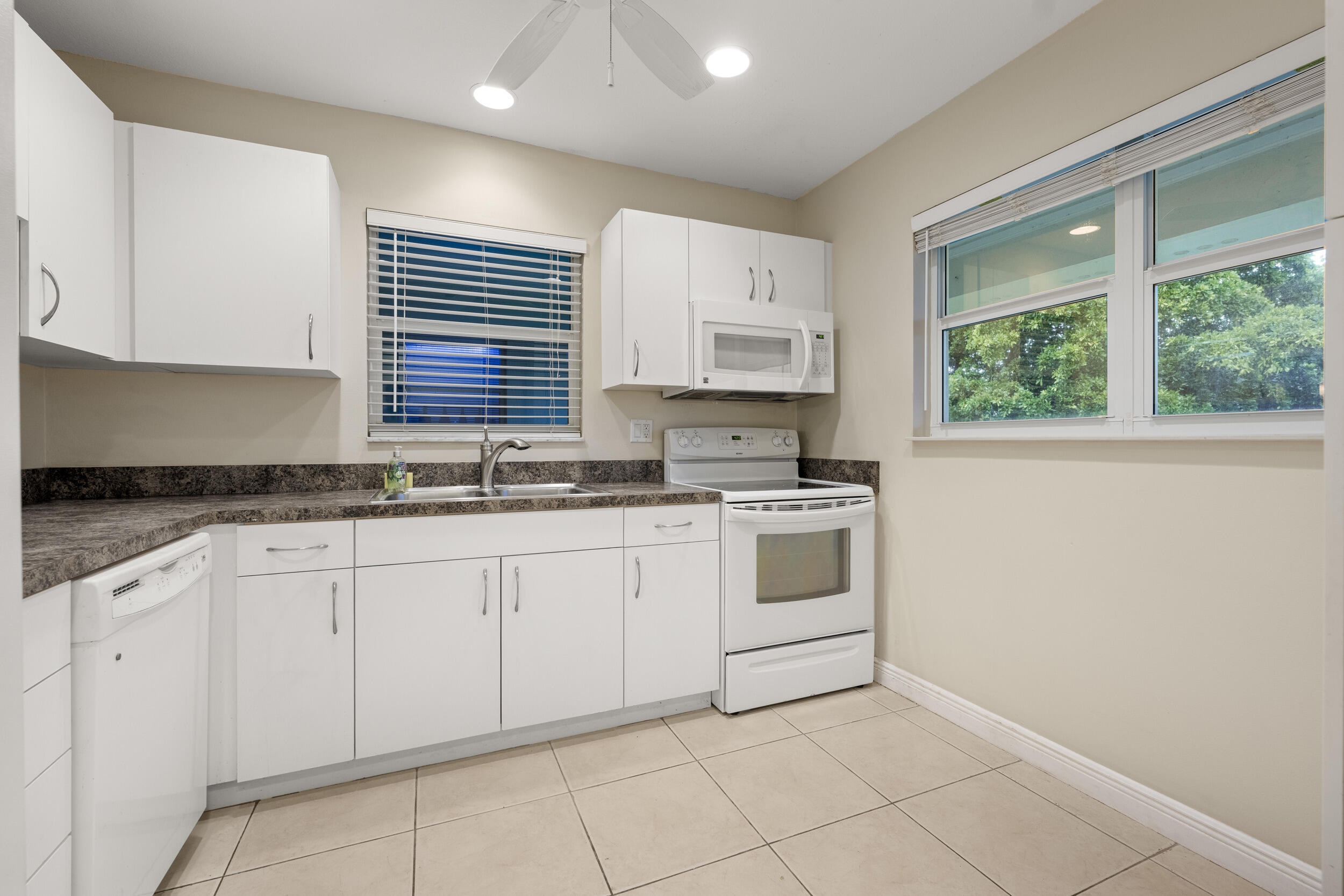1900 South Kanner Highway, Unit 4204 Stuart, FL 34994 - Photo 3 of 26 a kitchen with granite countertop white cabinets white appliances a sink and a window