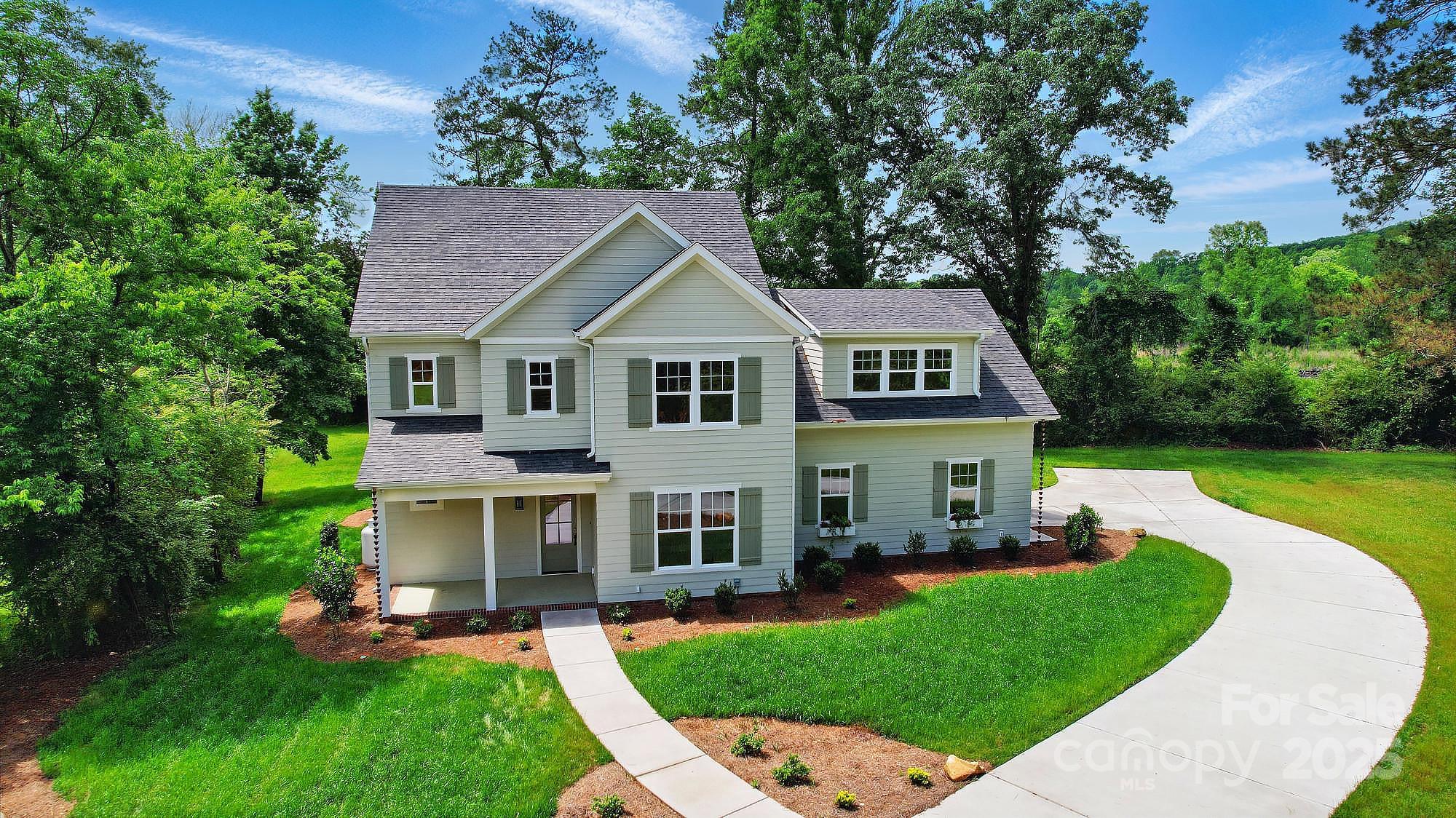 a aerial view of a house with a yard patio and a tree