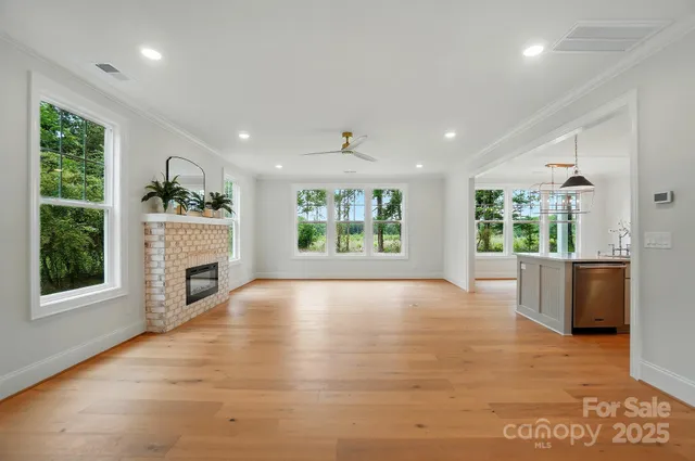 a view of an empty room with a fireplace and a window