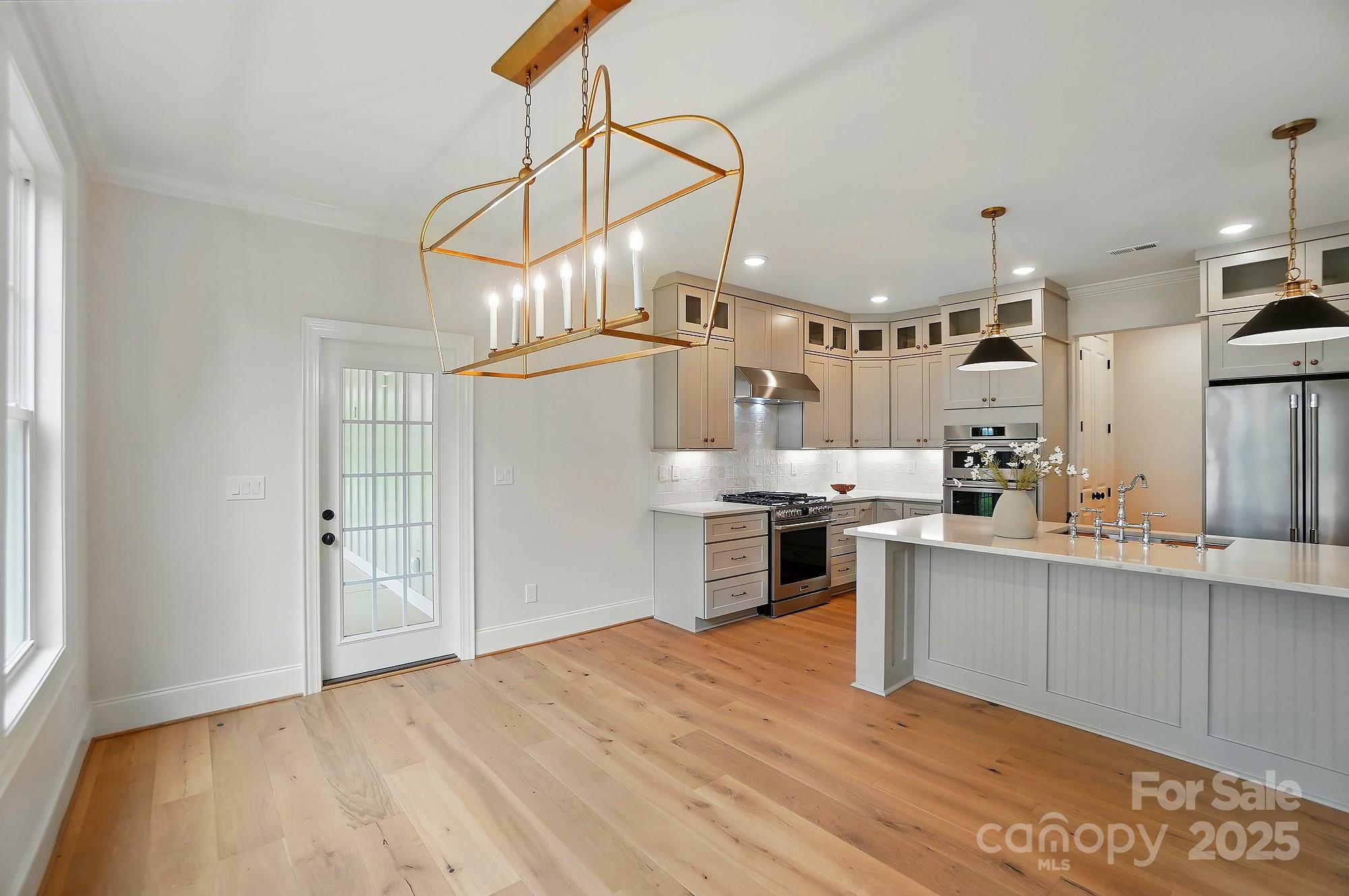 9315 Simpson Road Waxhaw, NC 28173 - Photo 19 of 45 a kitchen with stainless steel appliances granite countertop a sink cabinets and wooden floor