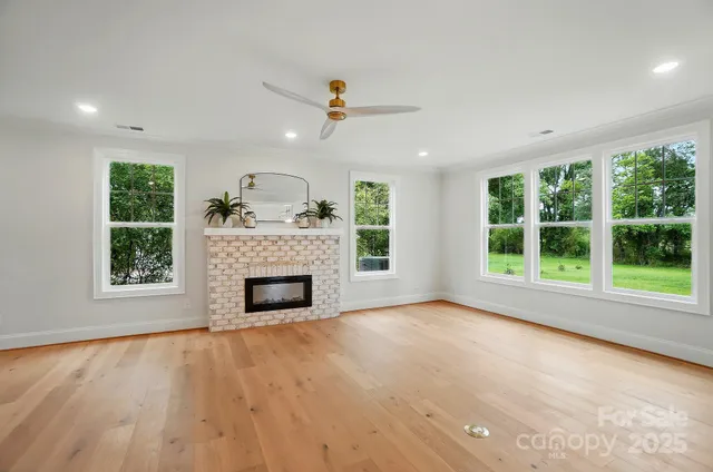 a view of an empty room with a fireplace and a window