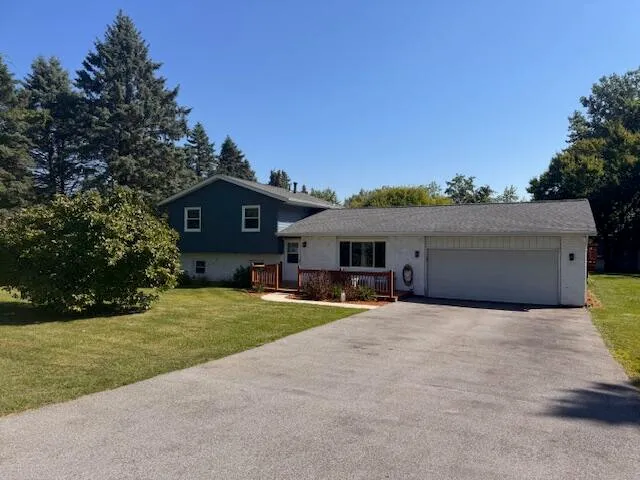 a view of house with outdoor space and trees in the background