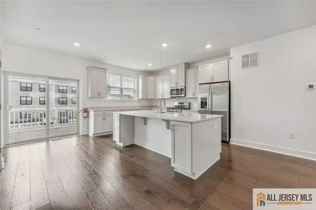 a kitchen with a refrigerator and a stove top oven