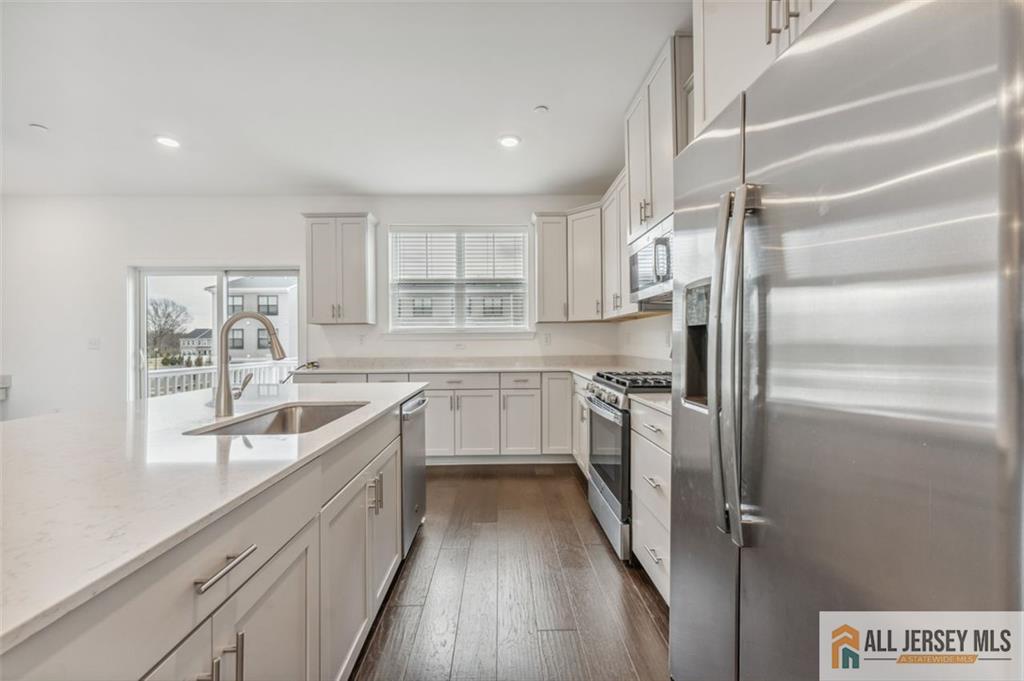 46 Mariveles Way Eatontown, NJ 07724 - Photo 6 of 26 a kitchen with a refrigerator a sink and dishwasher with wooden floor