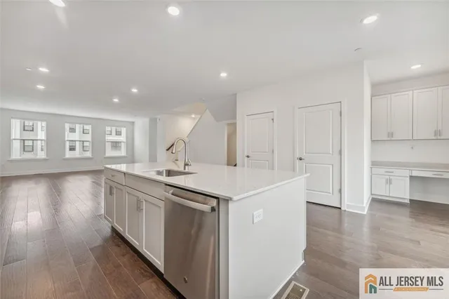 a kitchen with a sink and wooden floor