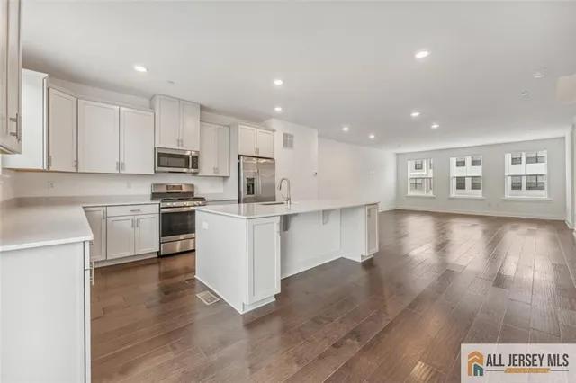 a kitchen with white cabinets and appliances