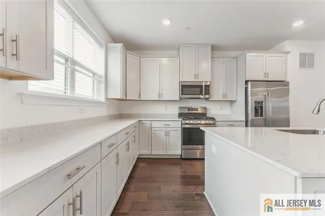 a kitchen with cabinets appliances a sink and a window