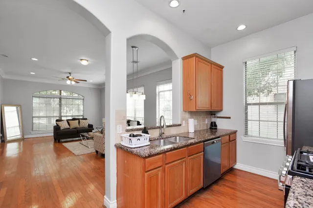 a kitchen with stainless steel appliances granite countertop a sink stove and wooden floor