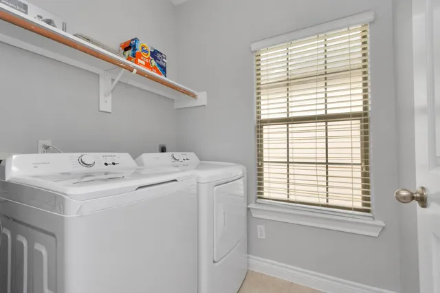 a utility room with dryer and window