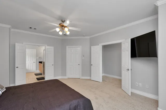 a bedroom with a bed and a chandelier fan