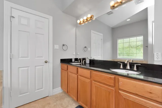a kitchen with granite countertop a sink a window and cabinets