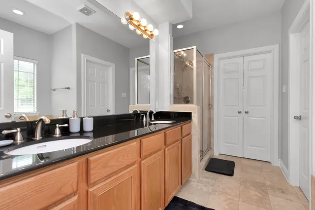 a bathroom with double vanity sinks a vanity and a mirror