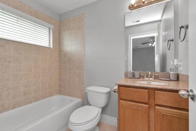a bathroom with a granite countertop toilet a sink and a bathtub