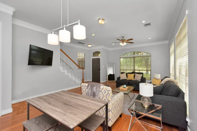 a living room with furniture a flat screen tv and a large window
